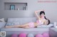 A woman in a pink lingerie laying on a couch.