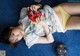 A young girl laying on the floor playing a video game.