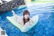 A woman laying on an inflatable raft in a swimming pool.